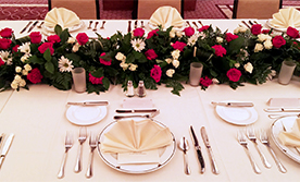 Formal wedding banquet table with plates and flower centerpiece