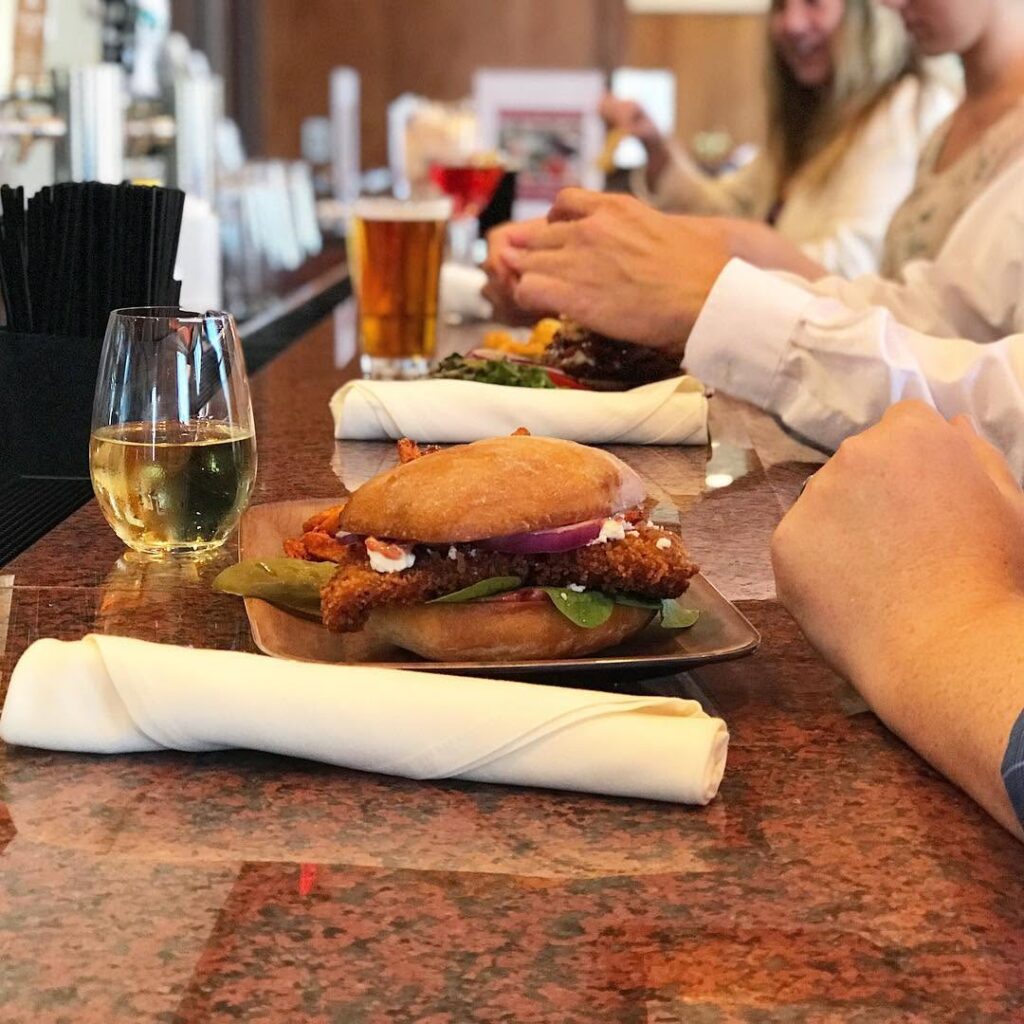 People at Smitty's pub bar eating sandwiches and enjoying various drinks